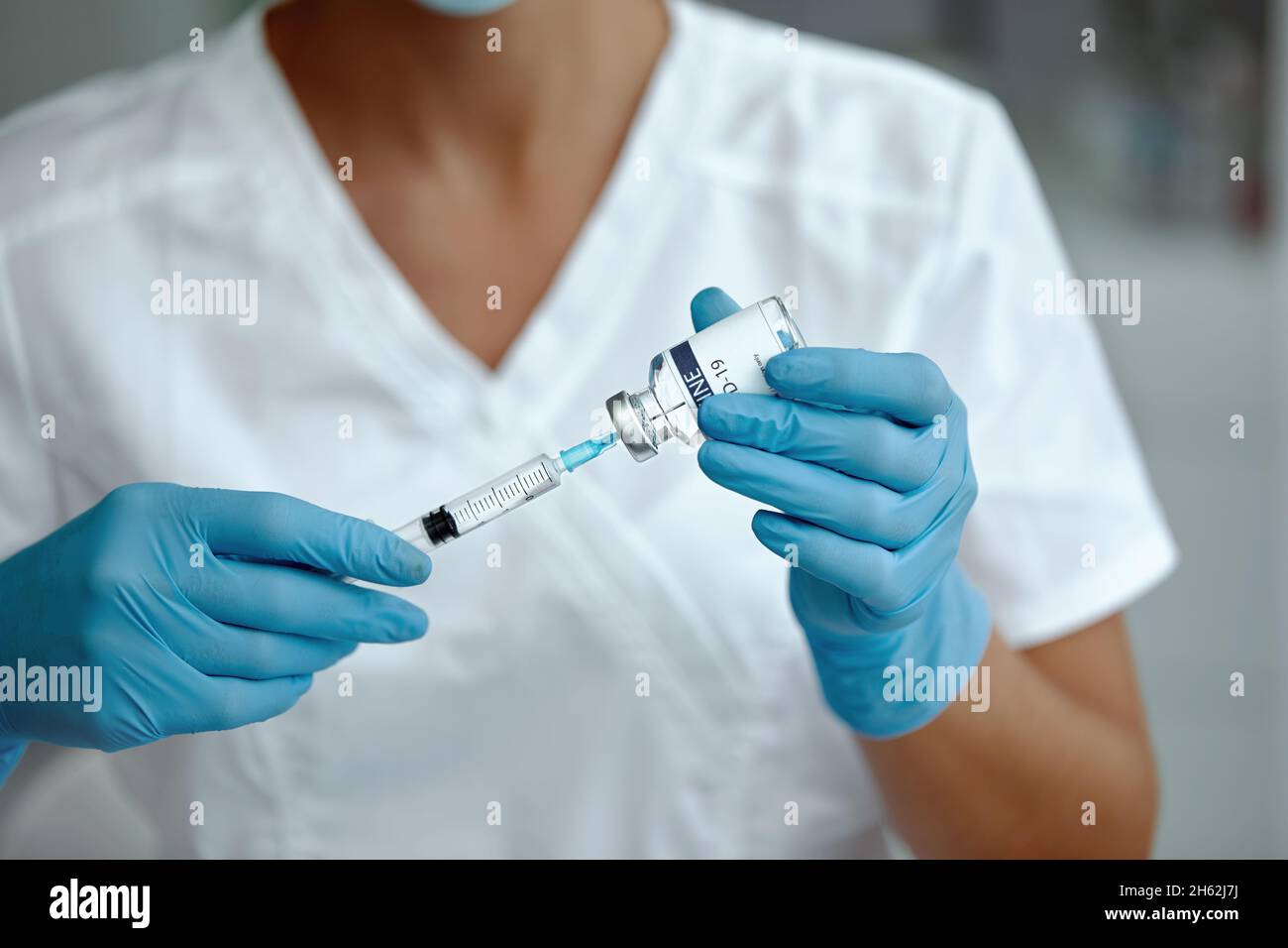 Woman doctor or scientist in laboratory holding a syringe with vaccines. Female holding COVID-19 vaccine in hand.  Concept:diseases,medical care,scien Stock Photo