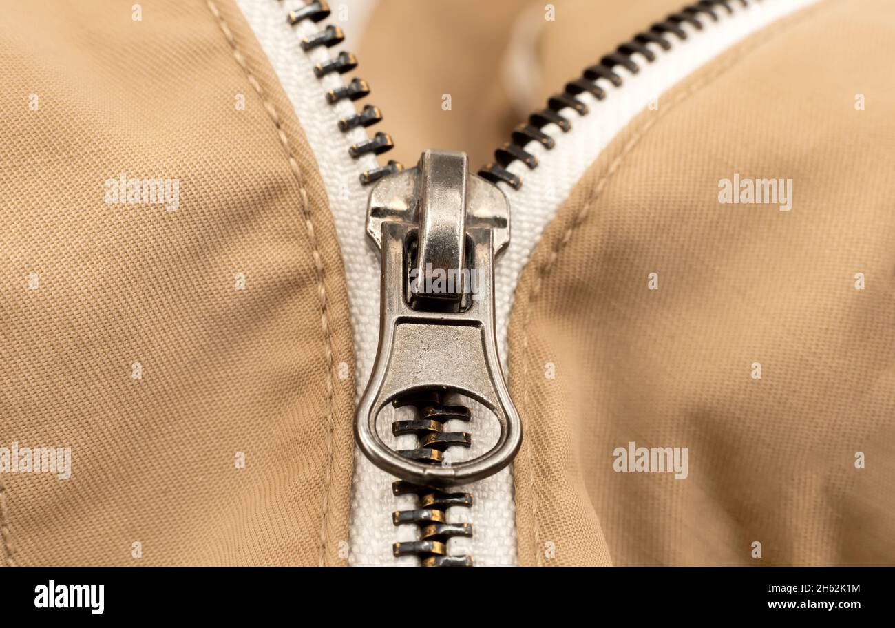 Closeup zip lock on lightcolored clothing, jacket. Zipper closure