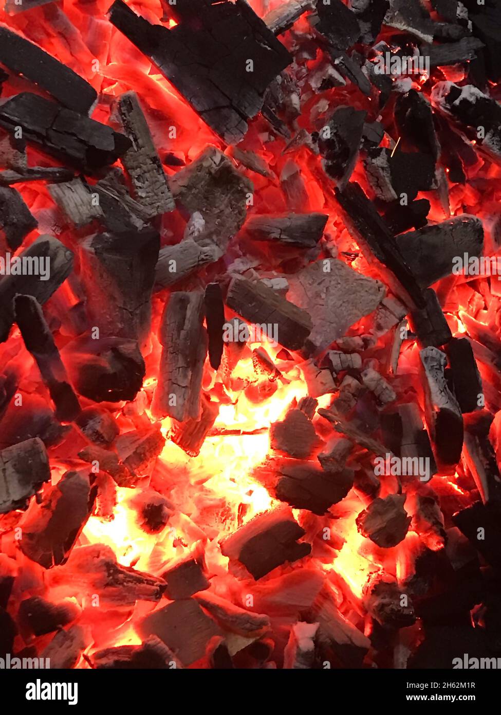 Smoldering charcoal in the grill at night.Background from a fire, conflagrant firewoods and coals.Closeup texture of burning charcoal Stock Photo