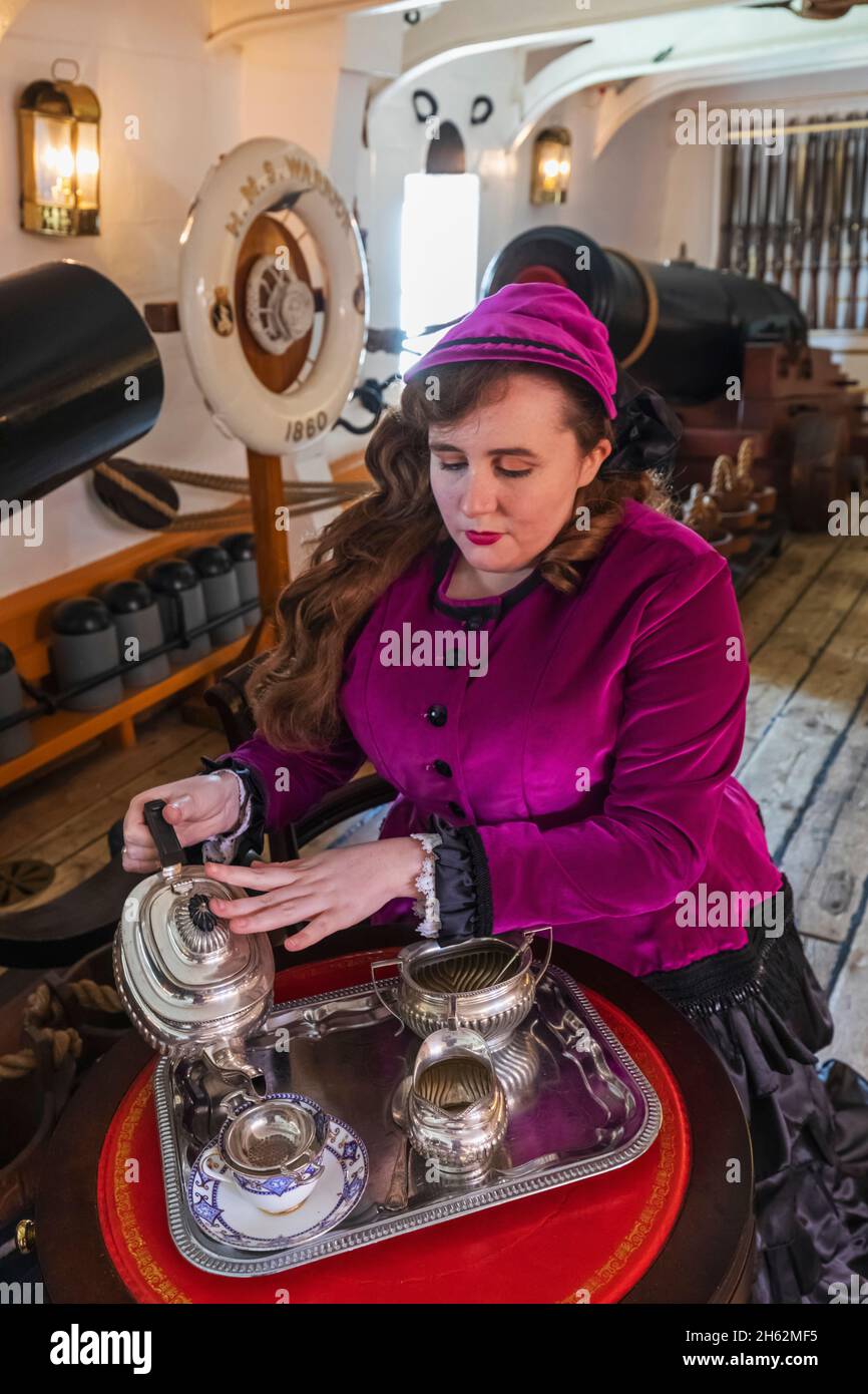 england,hampshire,portsmouth,portsmouth historic dockyard,hms warrior,lady dressed in period costume serving tea Stock Photo