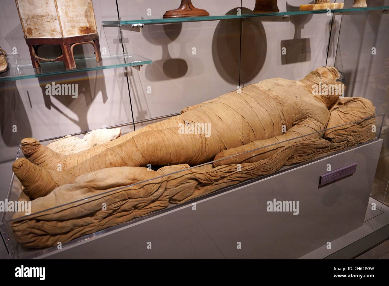 TURIN, ITALY - AUGUST 19, 2021: Mummy in a lying position. Mummification of one body during the Egyptian civilization, Egyptian Museum of Turin, Italy Stock Photo