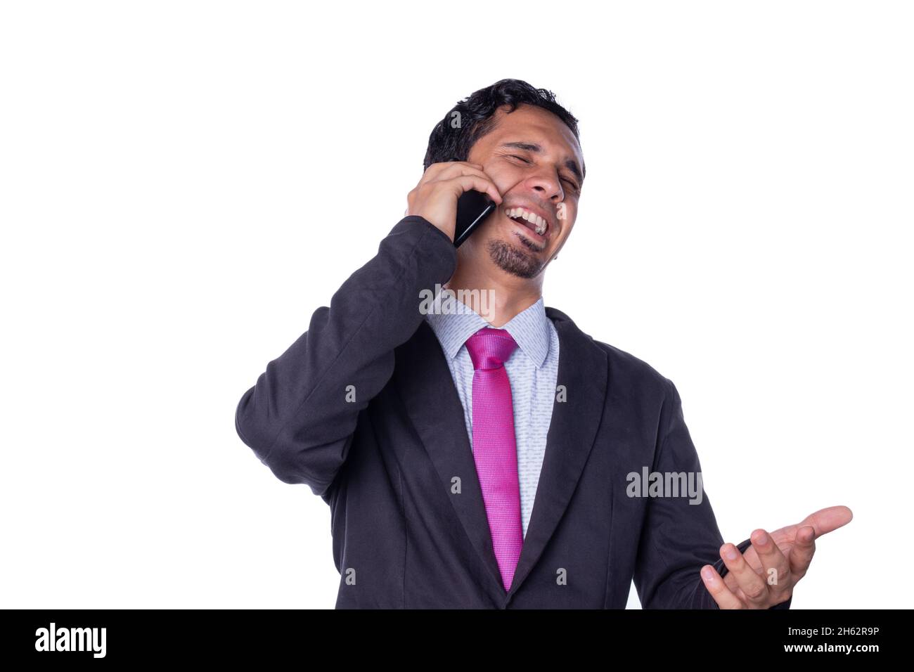 Businessman laughs while talking on the phone. Young adult using a smart phone. Concept of expressions of an entrepreneur. Person using technology Stock Photo