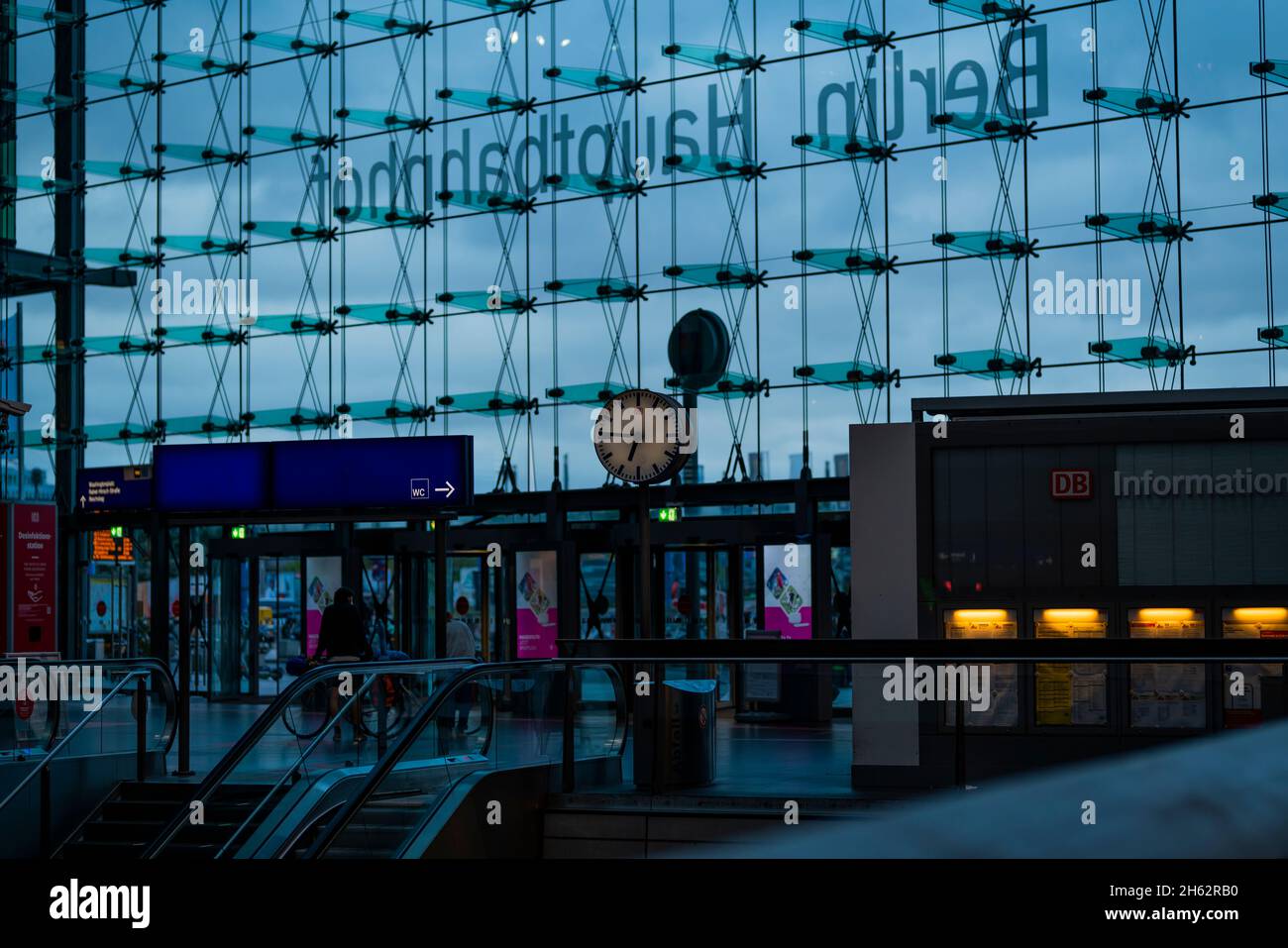 germany,berlin,station clock in the early morning in the main station in front of the glass facade Stock Photo