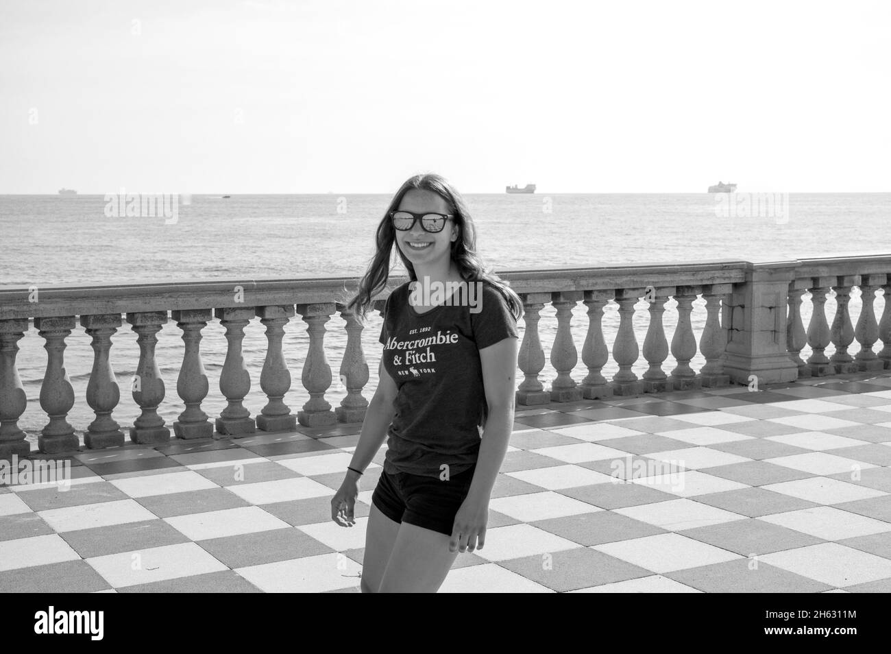 skater girl skating and jumping on terrazza mascagni in livorno,italy. its a wide sinuous belvedere toward the sea with a paving surface of 8700 sqm like a checkerboard and 4,100 balusters Stock Photo
