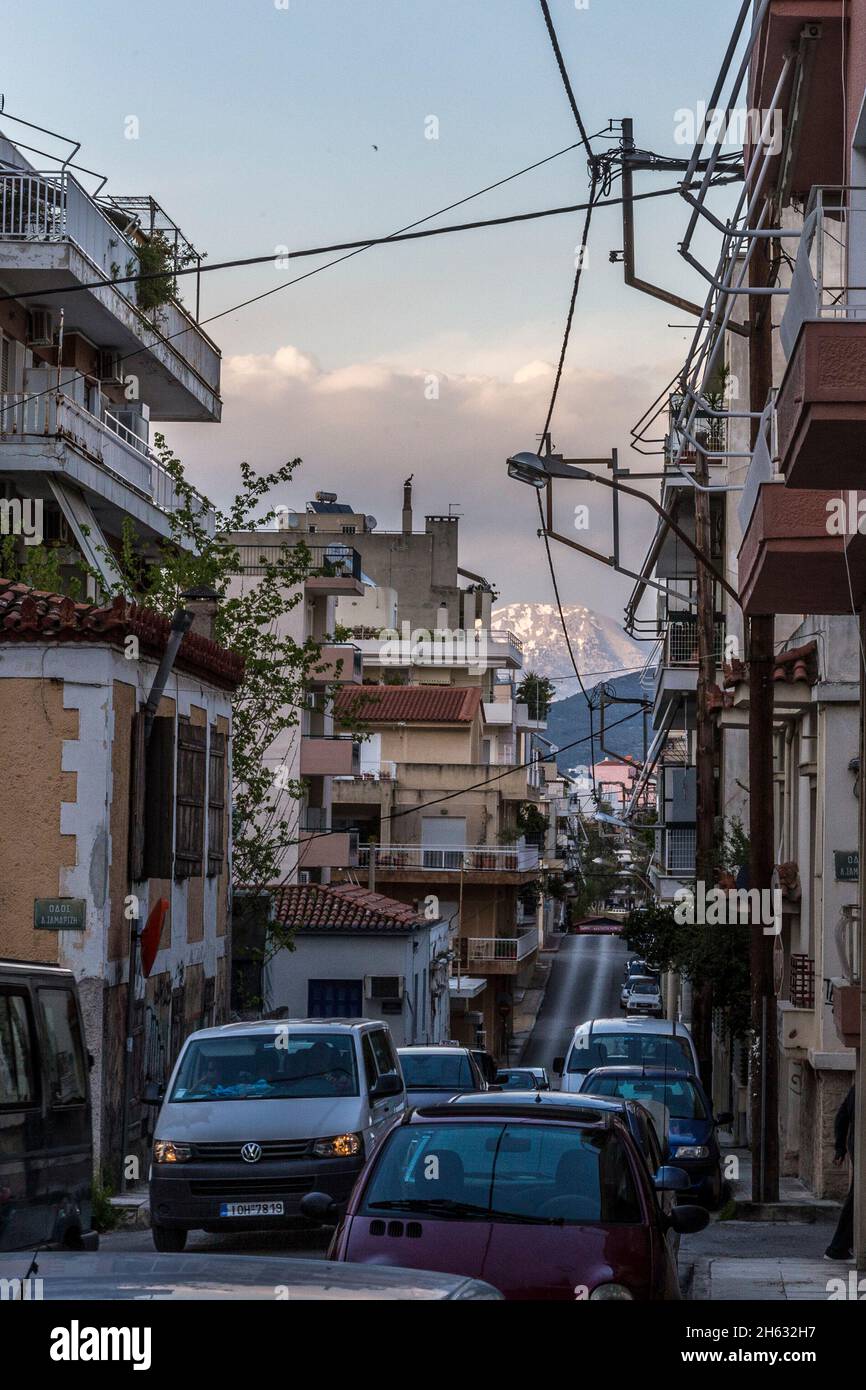 busy street in greece with cars and a snow-covered mountain in the back Stock Photo
