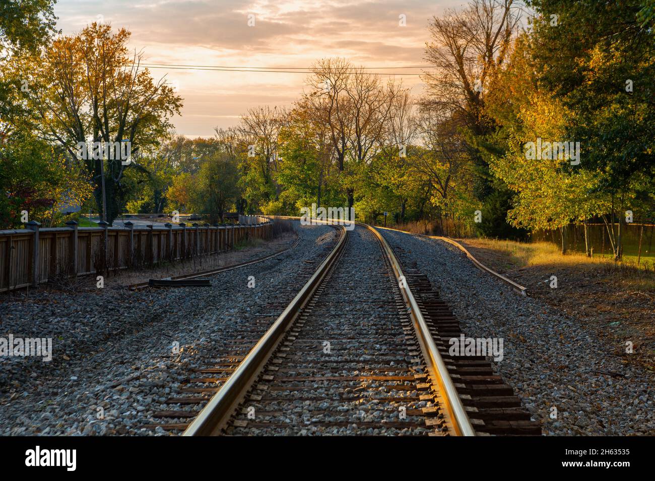 Late day sunlight creates warmth on a small town railroad track Stock Photo