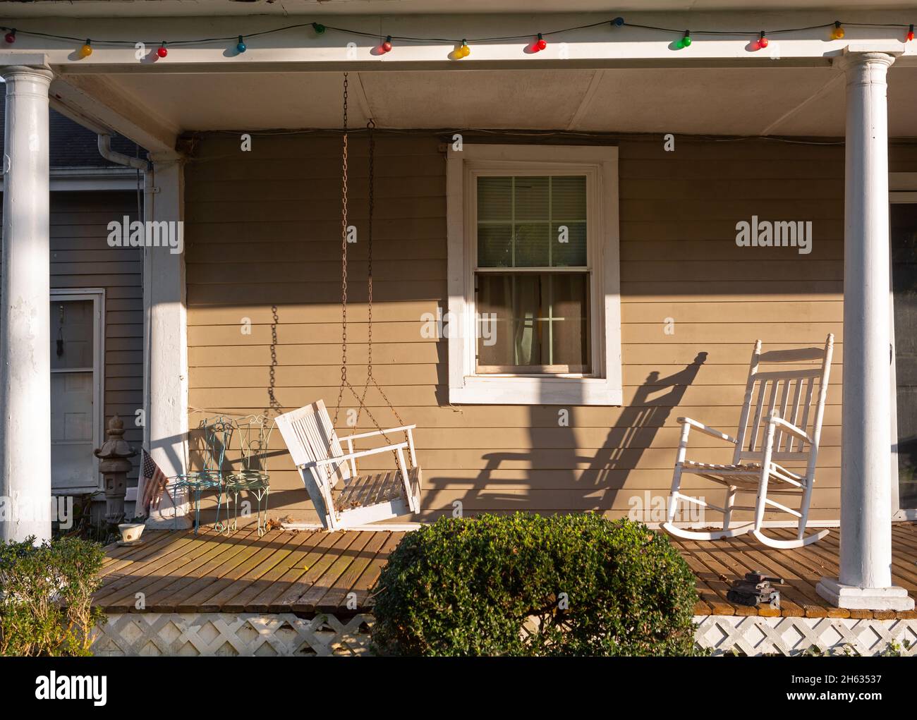 Front porch of old home with a swing and rocking chair Stock Photo - Alamy