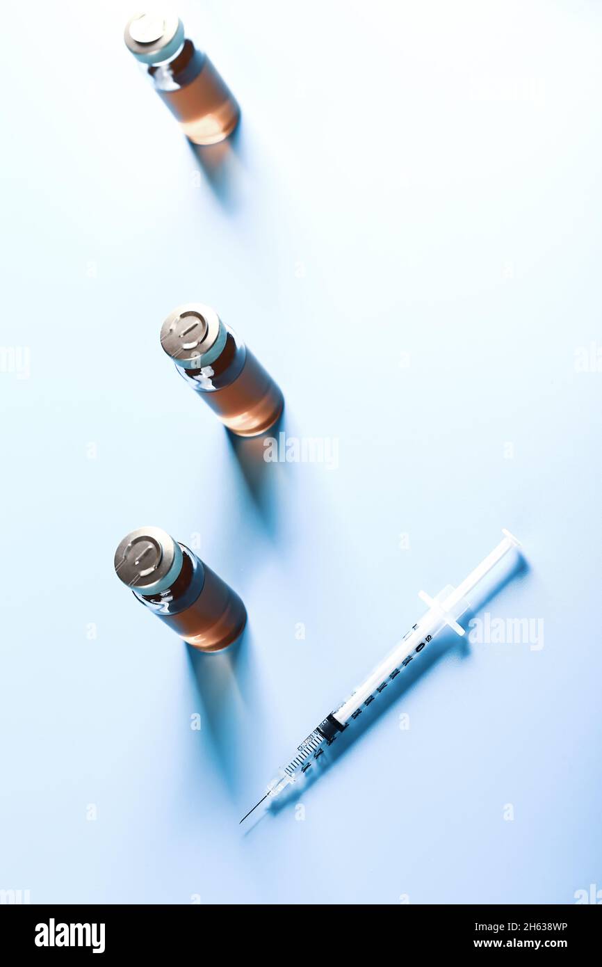 vaccine bottles on a blue background. medical concept. Very shallow depth of field. illumination across the frame Stock Photo