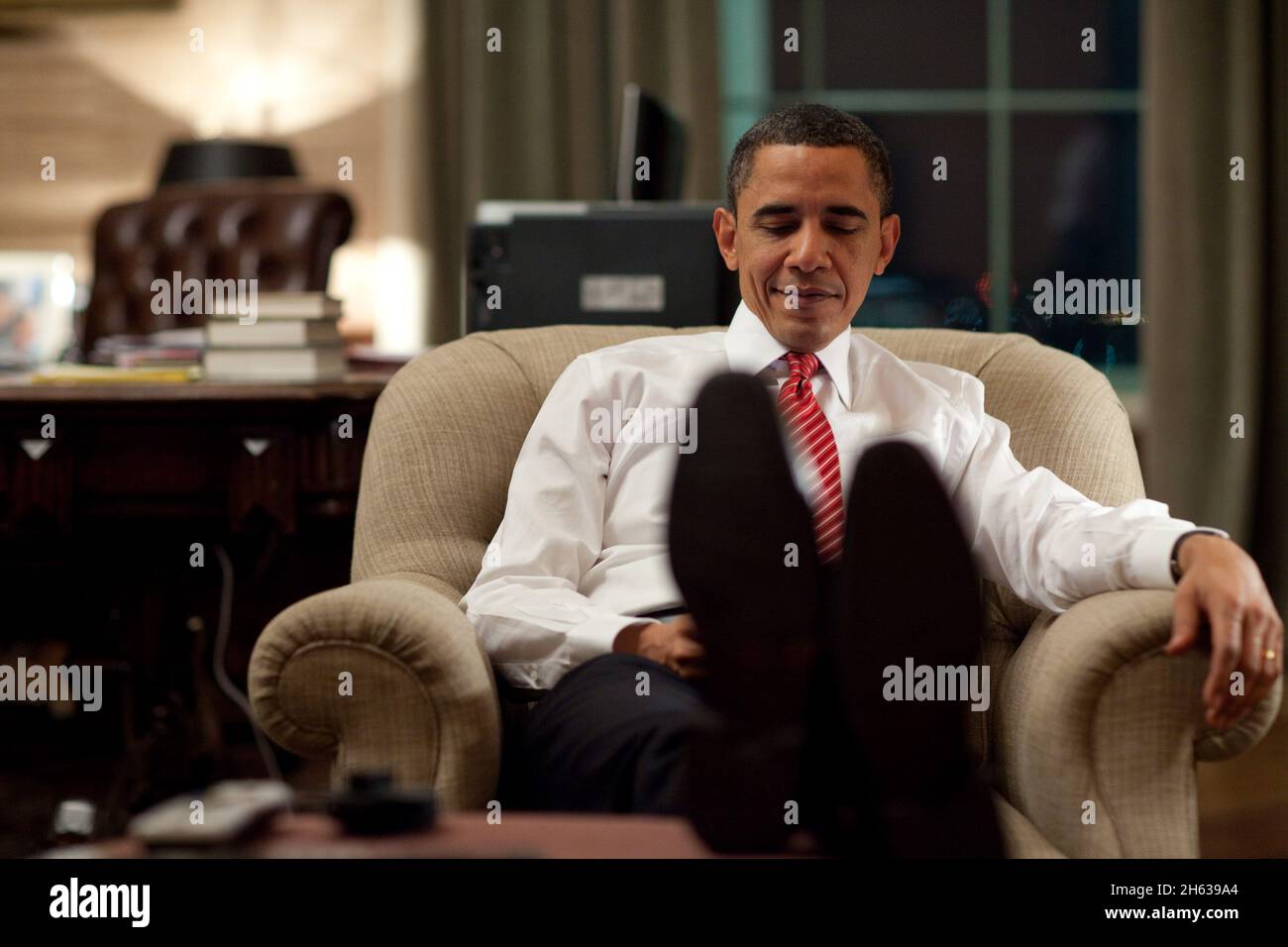President Barack Obama reacts to a BlackBerry message in the Treaty Room office in the private residence of the White House, March 21, 2010. Stock Photo