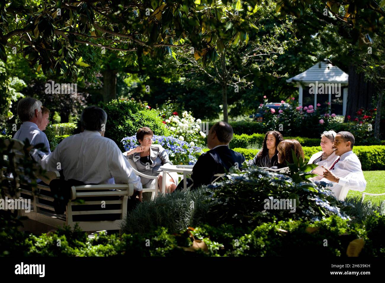 President Barack Obama and advisors sit around a table in the Rose Garden after moving their meeting outdoors on a warm spring day, May 20, 2009 Stock Photo