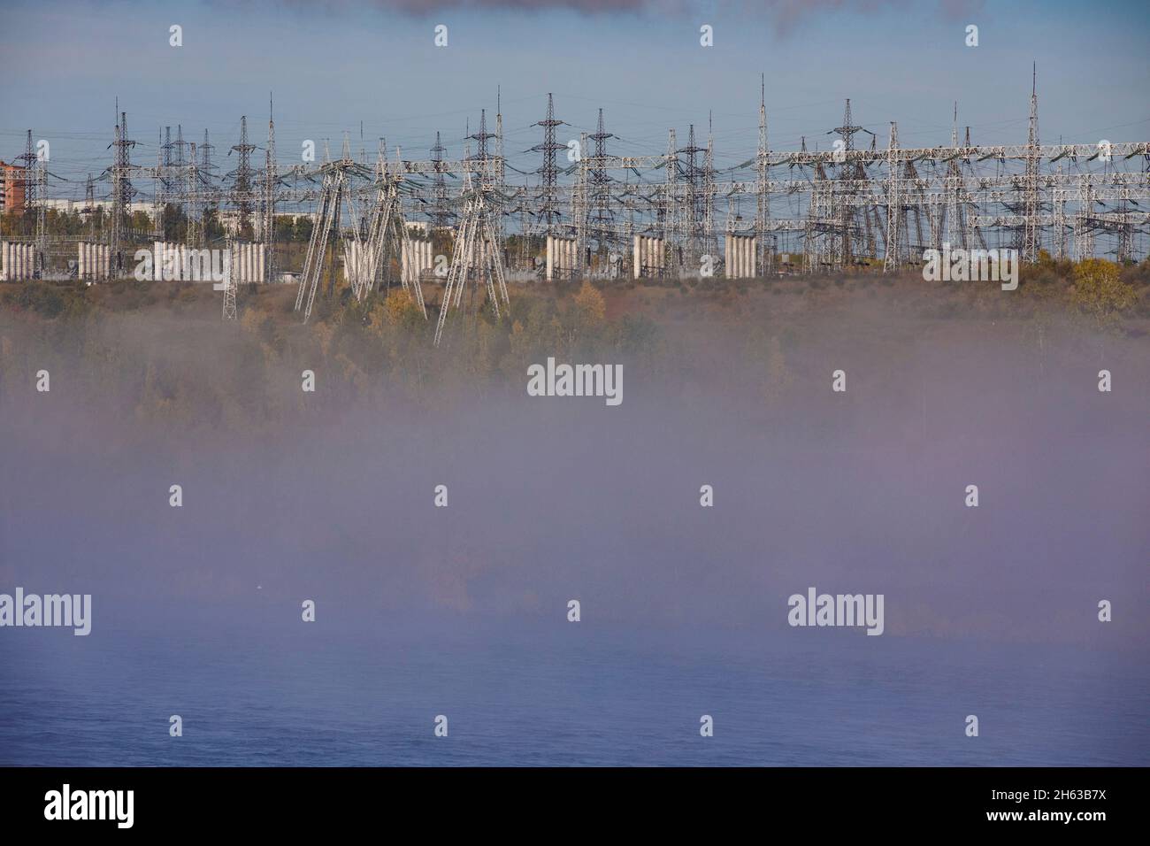 russia,siberia,bratsk,hydroelectric power station angara river,fog and substation with electricity pylons Stock Photo
