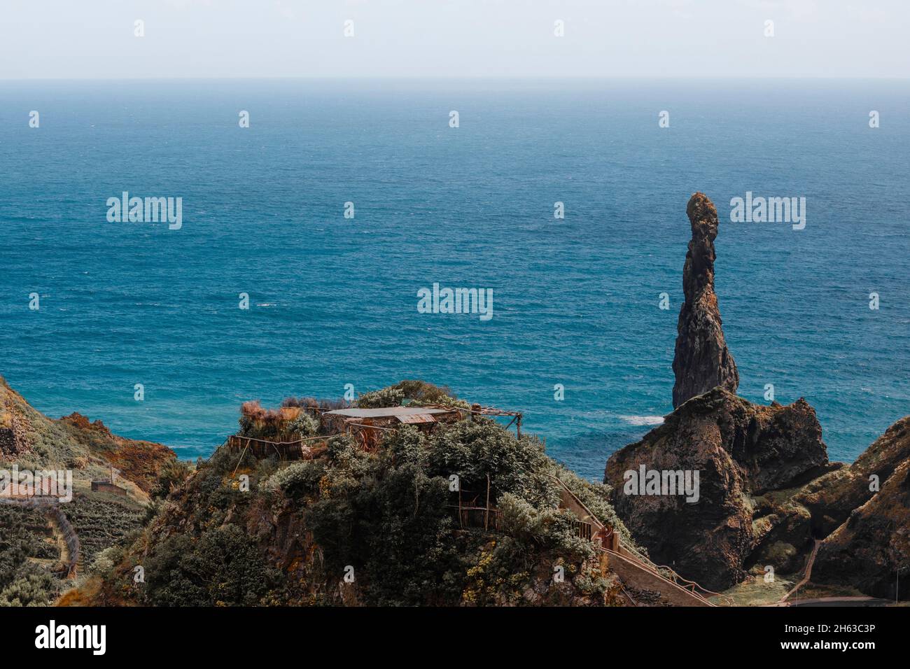 bizarre rock formation and residential house in the foreground on madeira island - Stock Photo
