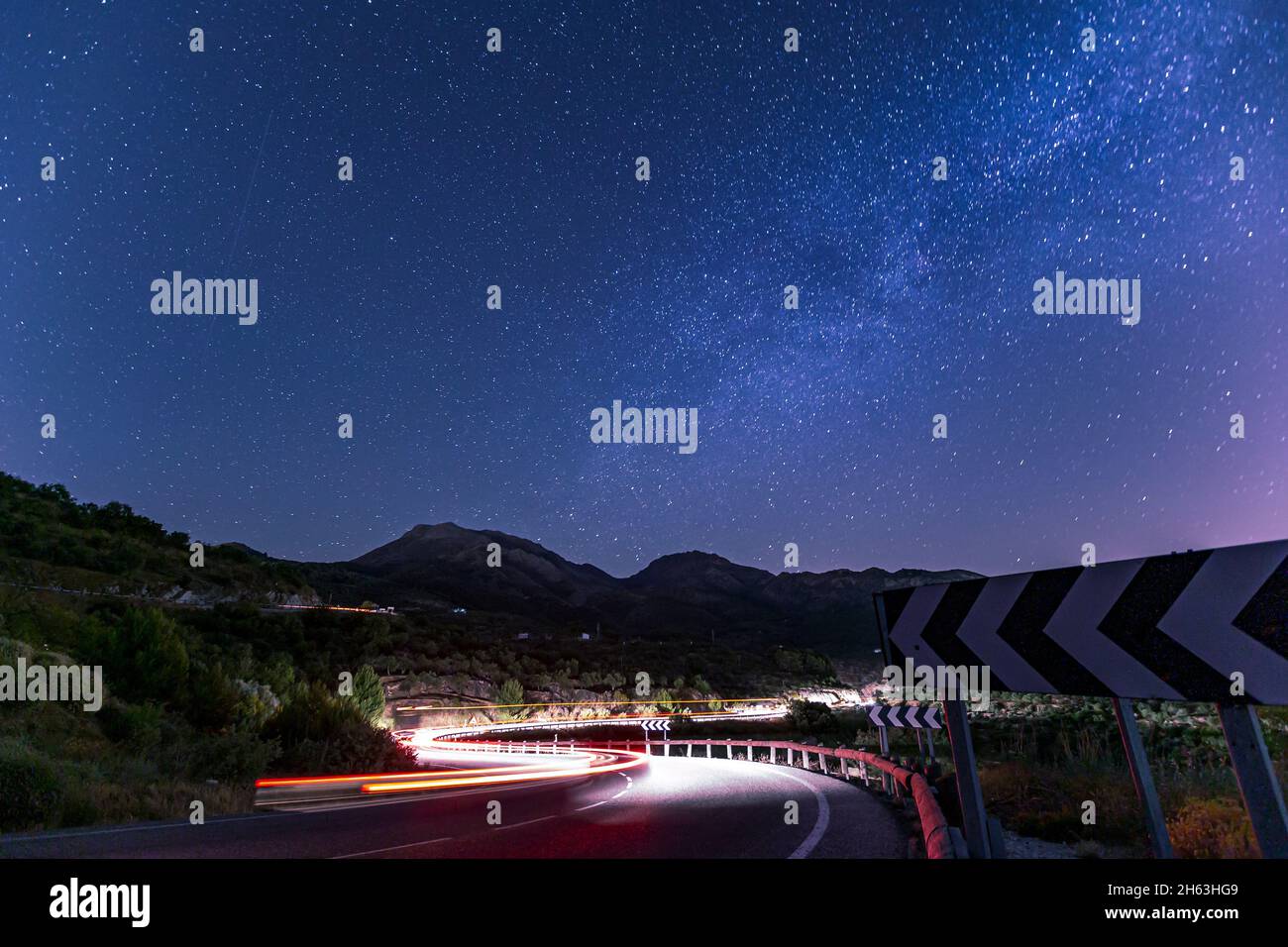 light trail of cars on a winding road with the stars above (milkey way) in andalusia,spain Stock Photo