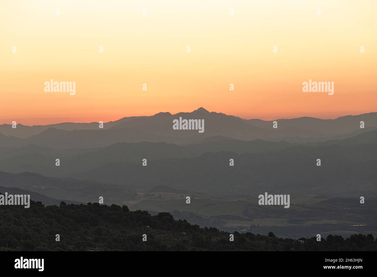 orange sky - just a few minutes before sunrise: pitoresque landscape shot taken at natural park of sierra de las nieves,andalusia,spain (hdr) Stock Photo