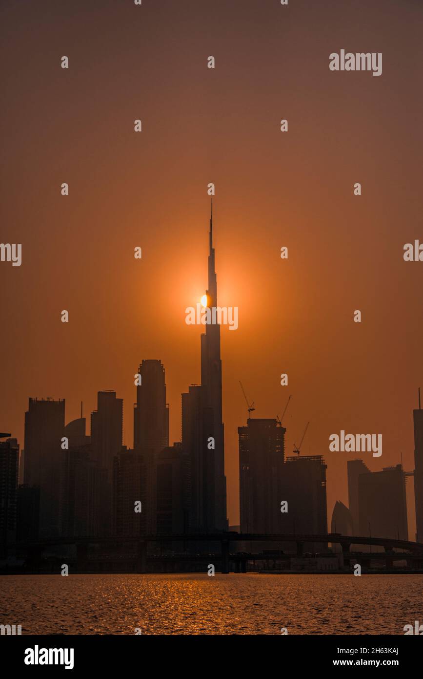 Burj Khalifa with setting sun Dubai Canal UAE Stock Photo