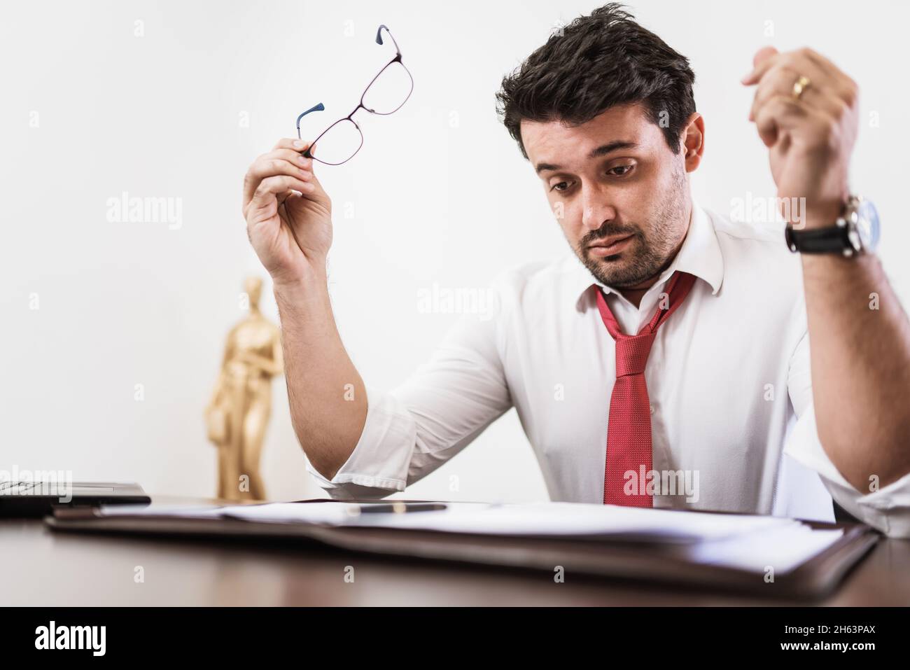 Young Latin male lawyer or employee working night in the office Stock Photo