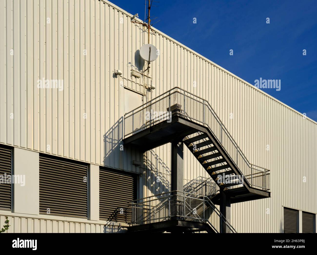 white warehouse with outside stairs,blue sky, Stock Photo