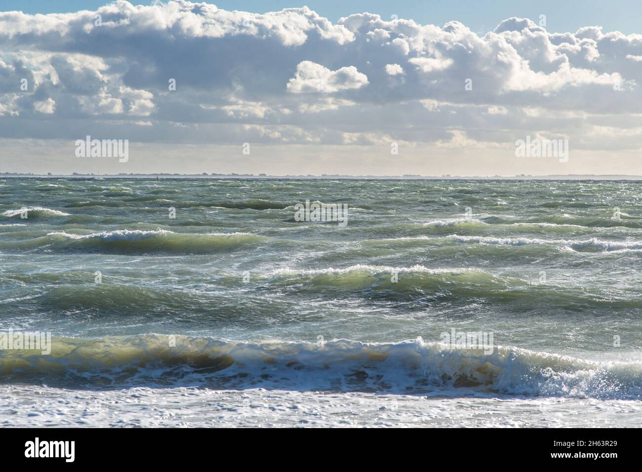 moderate surf with partly cloudy skies on the north sea beach near neeltje jans. Stock Photo
