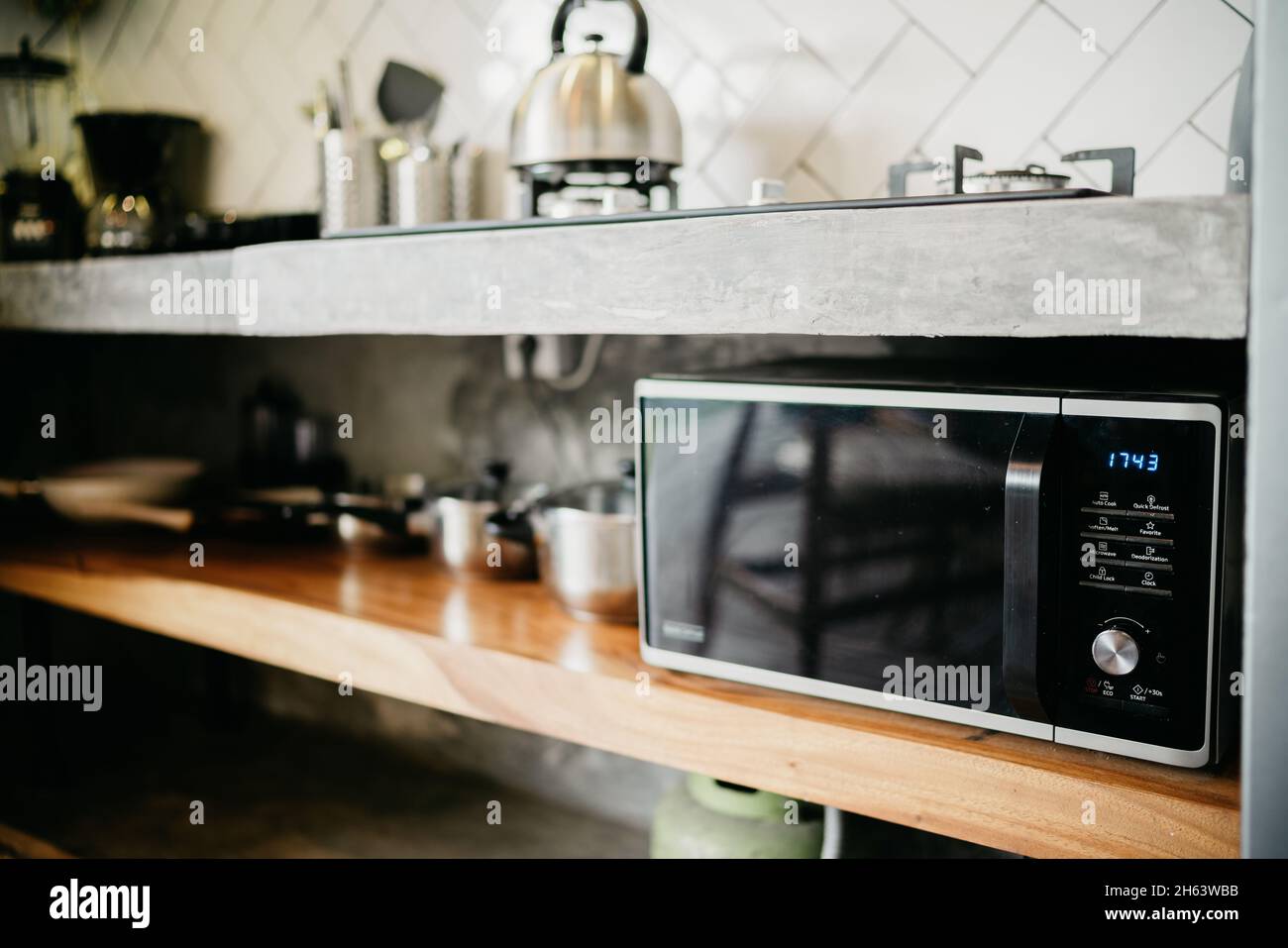 Closeup microwave and stainless electric kettle in modern kitchen