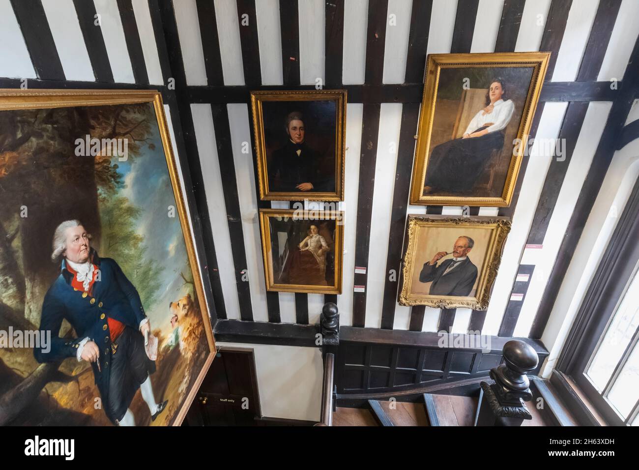 england,southampton,tudor house and garden museum,interior view showing wooden staircase and artworks Stock Photo