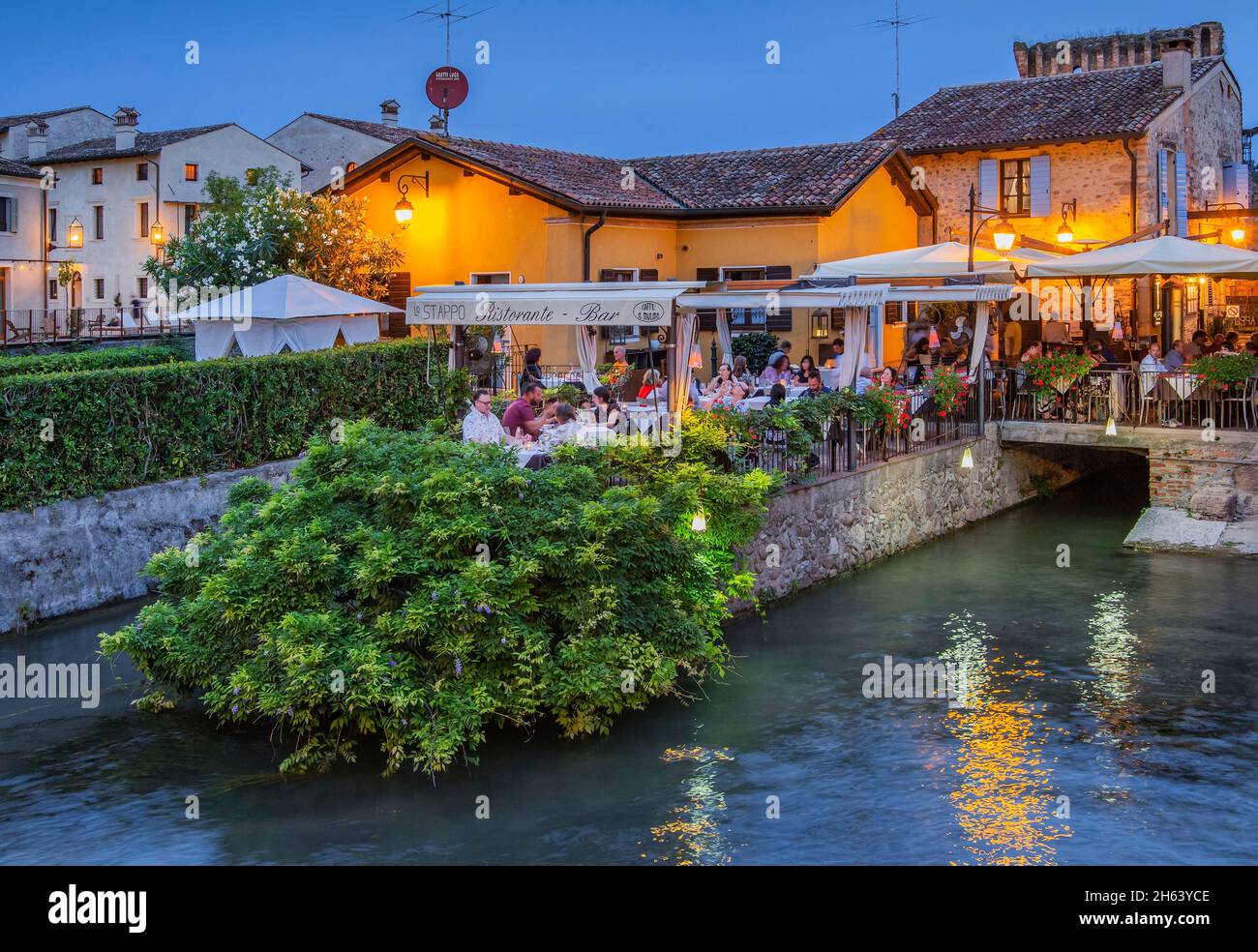 restaurant terrace on the mincio river at dusk,borghetto,district of valeggio sul mincio,mill village,po plain,verona province,veneto,italy Stock Photo