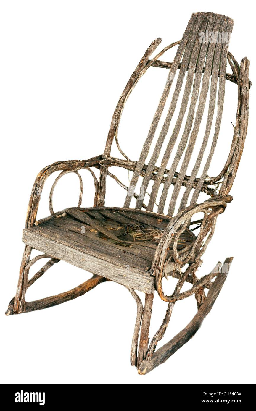 Amish rocking chair made from oak and hickory weathered worn antique possibly from 1920-1930. Hand made bentwood twig with broken middle seat. Stock Photo