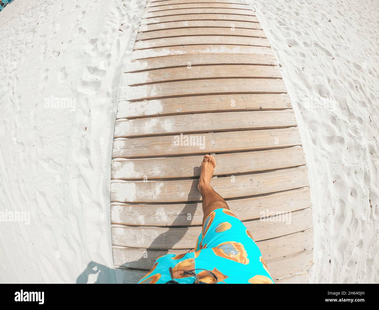 pov and first view of person walking in a white beach looking to the blue sea or ocean in a sunny day of vacation Stock Photo
