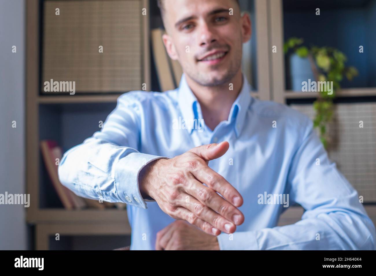 head shot portrait smiling businessman wearing glasses extending hand for handshake at camera,friendly hr manager greeting candidate on interview,offering deal,welcoming client at meeting Stock Photo