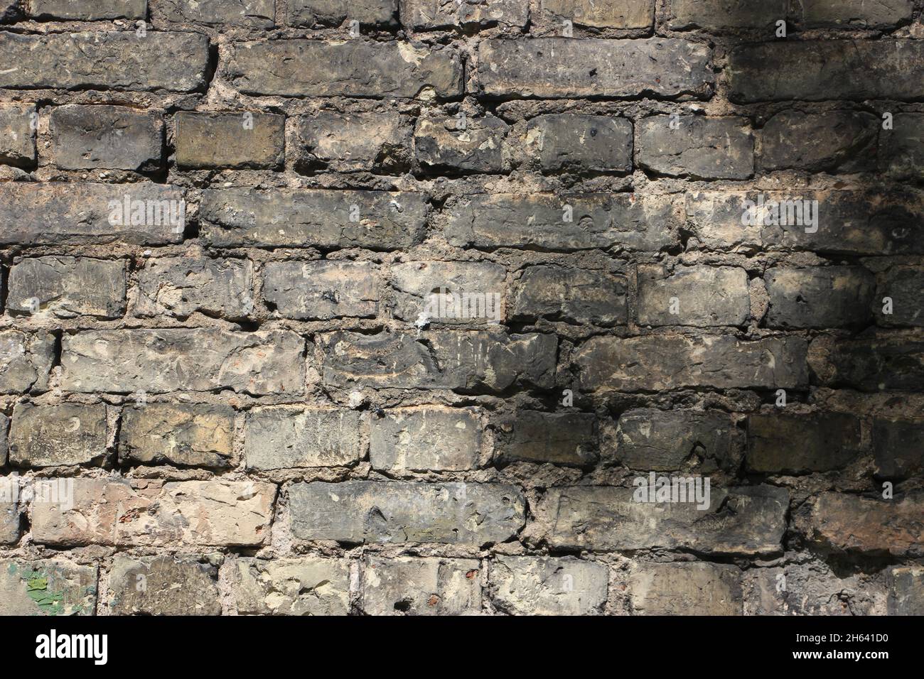 Background of old vintage dirty brick wall with peeling plaster, texture. Stock Photo