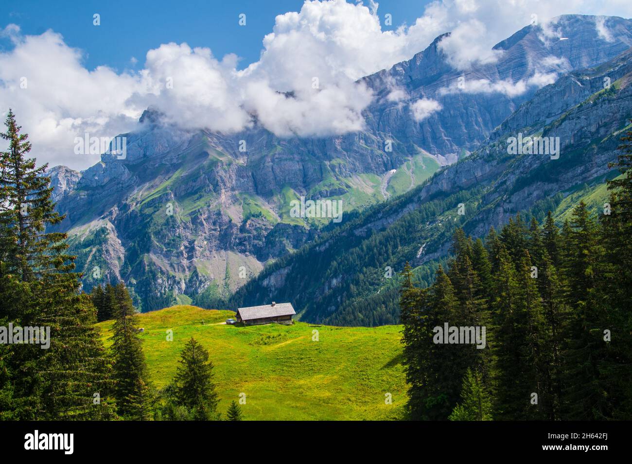 Aerial view of the rocky green mountains under the cloudy blue sky ...