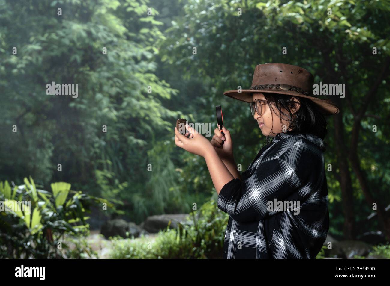 Student girl doing research in the forest as the background. Stock Photo