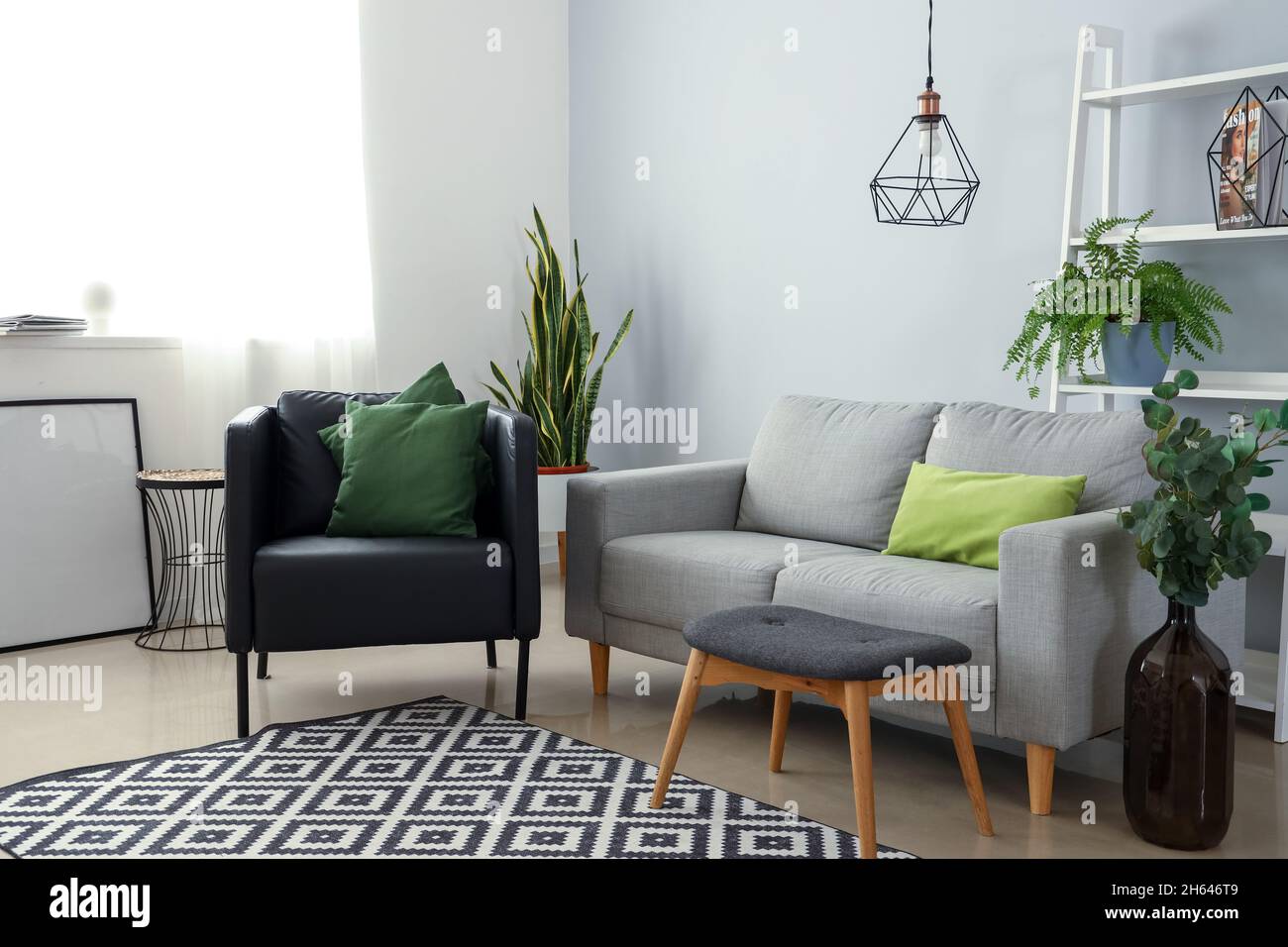Interior of modern living room with armchair, sofa and houseplants ...
