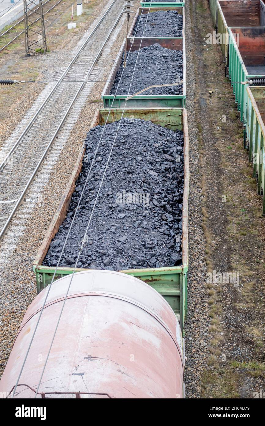 Freight train open cars loaded with coal cargo, stationary in a depot on rails. Karaganda, Kazakhstan, Central Asia Stock Photo