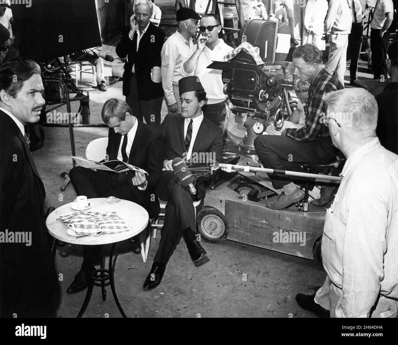 MICHAEL STRONG DAVID McCALLUM as Illya Kuryakin and ROBERT VAUGHN as Napoleon Solo on set candid with Camera / Movie Crew during filming of THE DEADLY GODDESS AFFAIR 1966 (Season  2 Episode 17) director SEYMOUR ROBBIE of THE MAN FROM U.N.C.L.E. US TV Series 1964 - 1968) creator Sam Rolfe Arena Productions / MGM Television Stock Photo