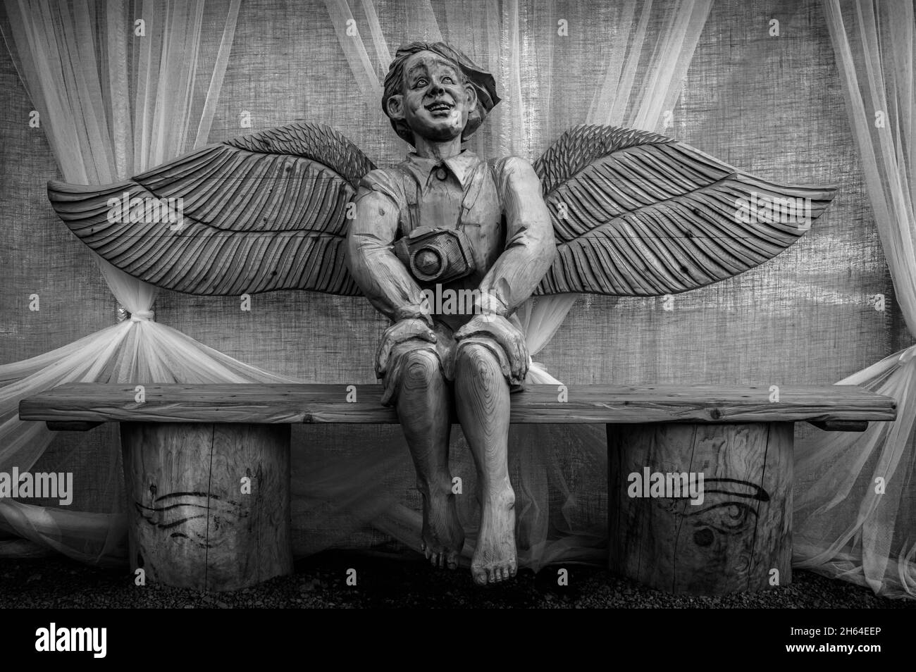 Wooden sculpture of a smiling angel in Ruskeala Mountain Park. Karelia, Russia. Black and white. Stock Photo