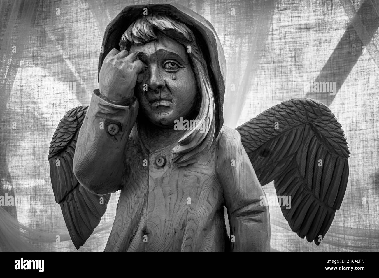 Wooden sculpture of a weeping angel in Ruskeala Mountain Park. Karelia, Russia. Black and white. Stock Photo