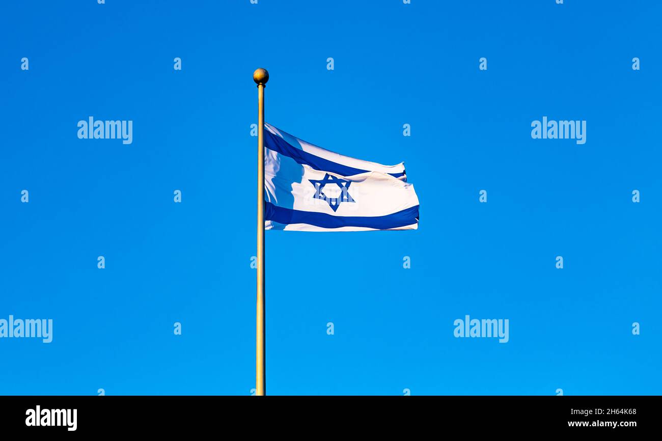 National flag of Israel waving outdoors on the background of blue sky ...