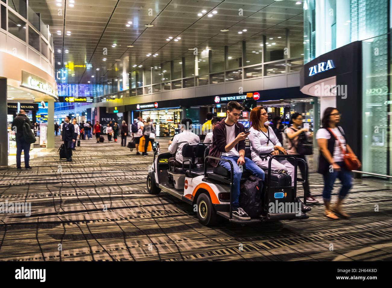 Passengers travelling on electric buggy in Changi Airport,  Terminal 3, Singapore. Stock Photo