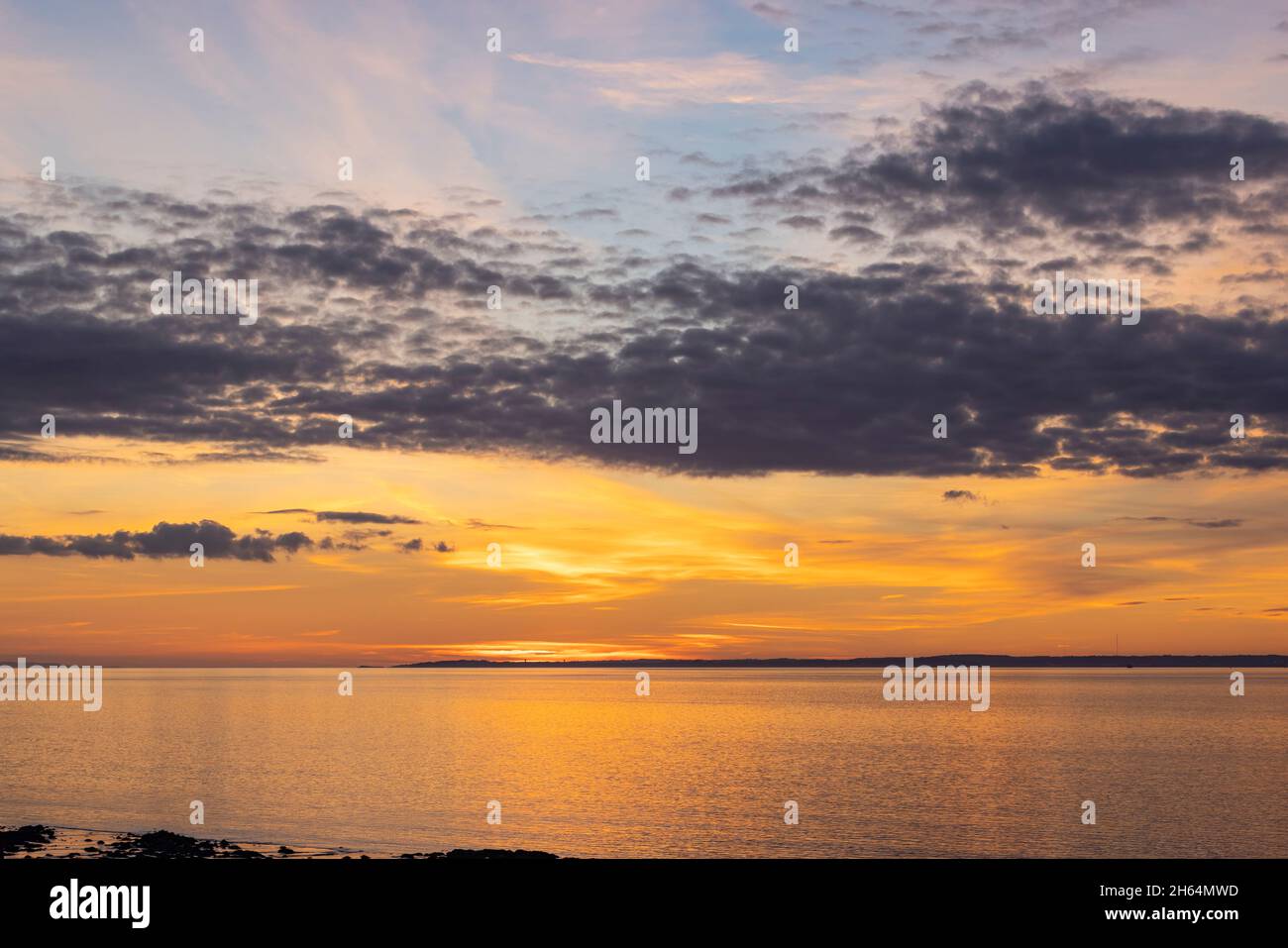 Calm Sea Setting The setting sun lighting up the sky and reflecting onto a calm sea ...