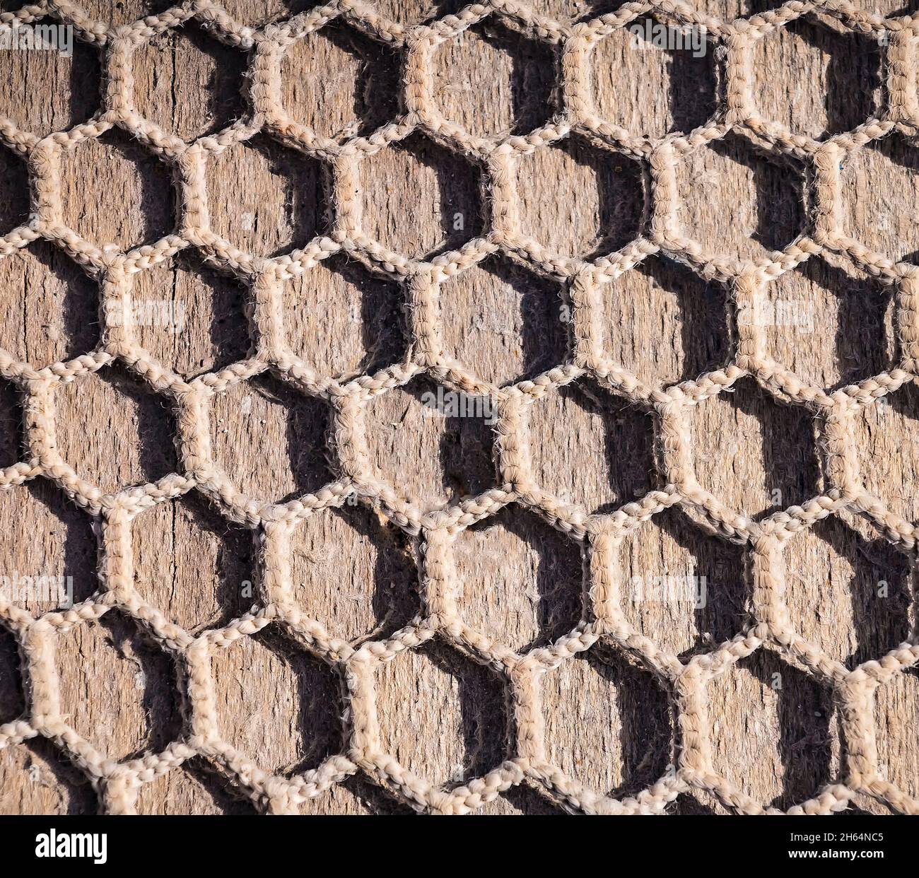 Fishnet on brown wooden floor or de?k. Mesh fabric. Fishing net background  Stock Photo - Alamy