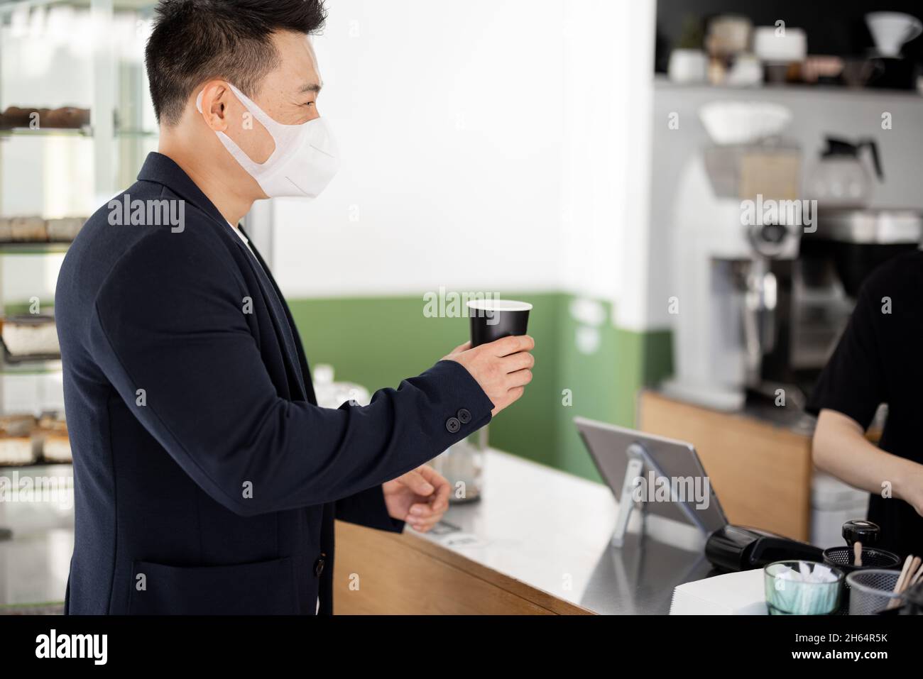 Asian man in medical with coffee going in store Stock Photo