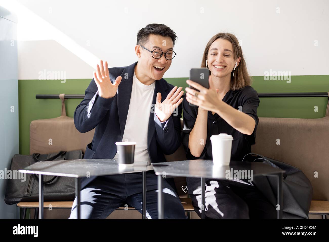Couple having video call on smartphone in cafe Stock Photo