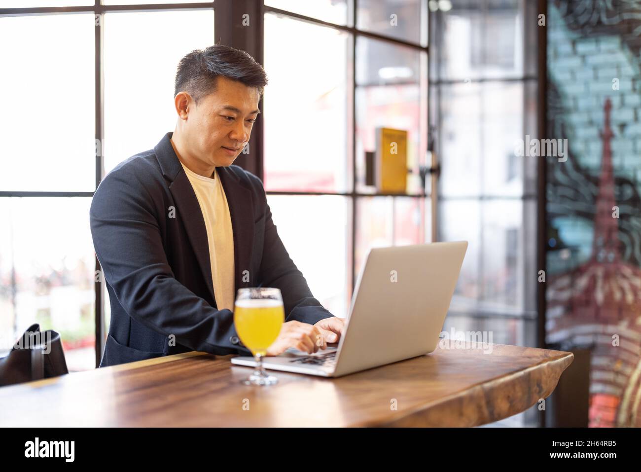 Man working on laptop in bar Stock Photo