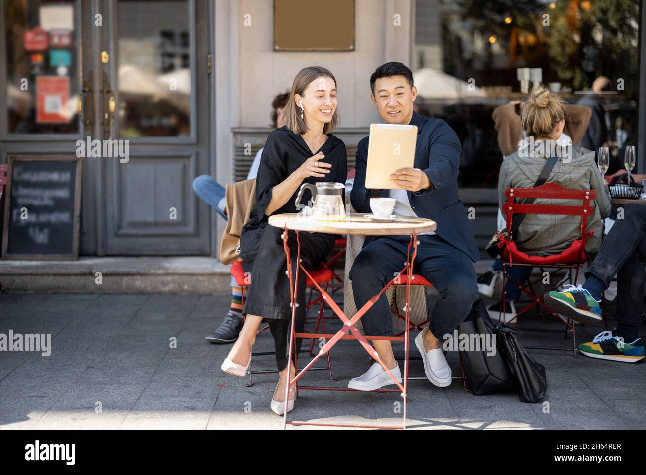 People having video call on digital tablet at cafe Stock Photo