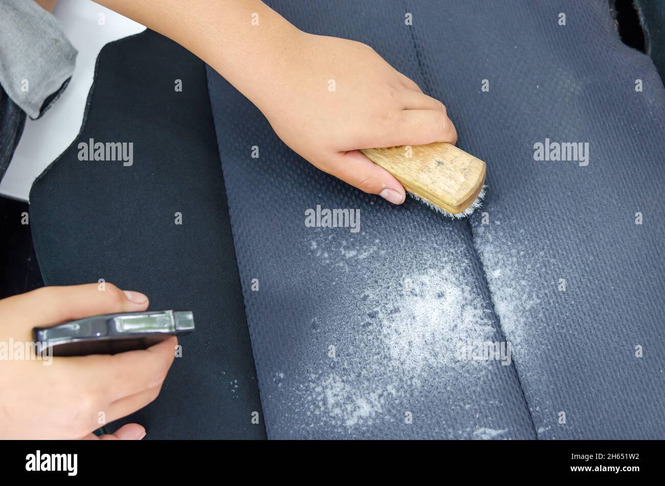 man with a hand to scrub brush to clean upholstery Stock Photo