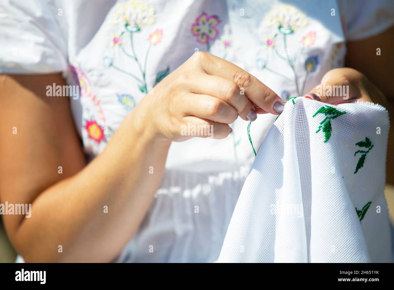 Hands are embroidered with a cross. Needlework and folk art. Stock Photo