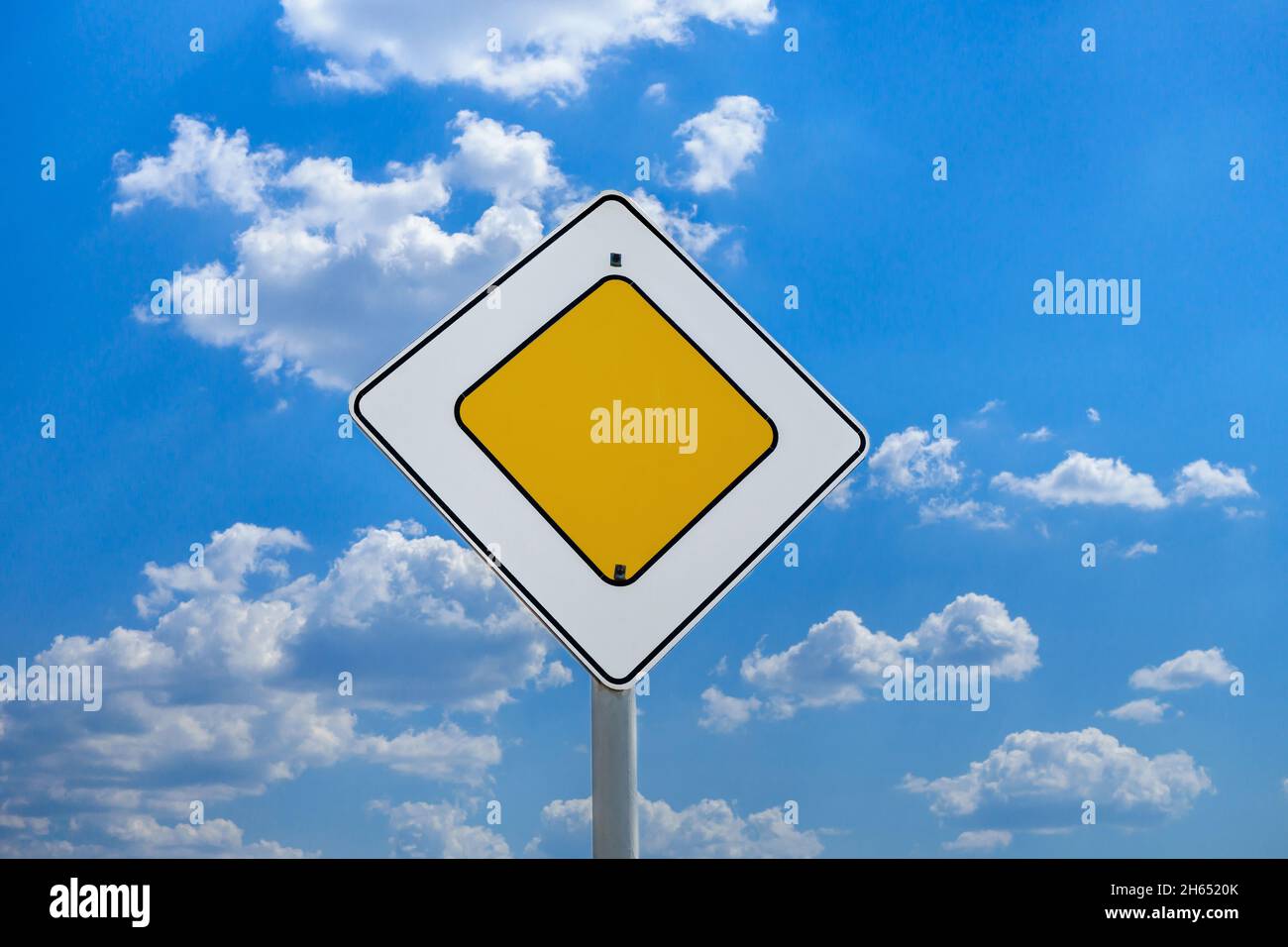 International road sign 'Main road' or 'Priority road' against a blue and slightly cloudy sky Stock Photo