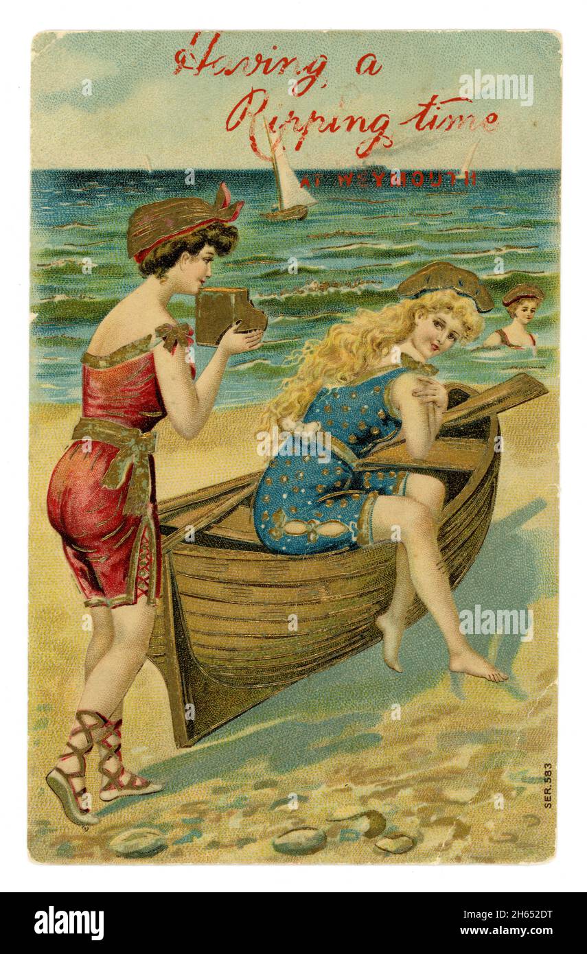 Charming original Edwardian illustrated colour embossed card embellished with gold, of beautiful bathing beauties, one sitting on a rowing boat, one holding a camera, Having a Ripping Time at Weymouth, (Dorset, England U.K.) circa 1905. Stock Photo