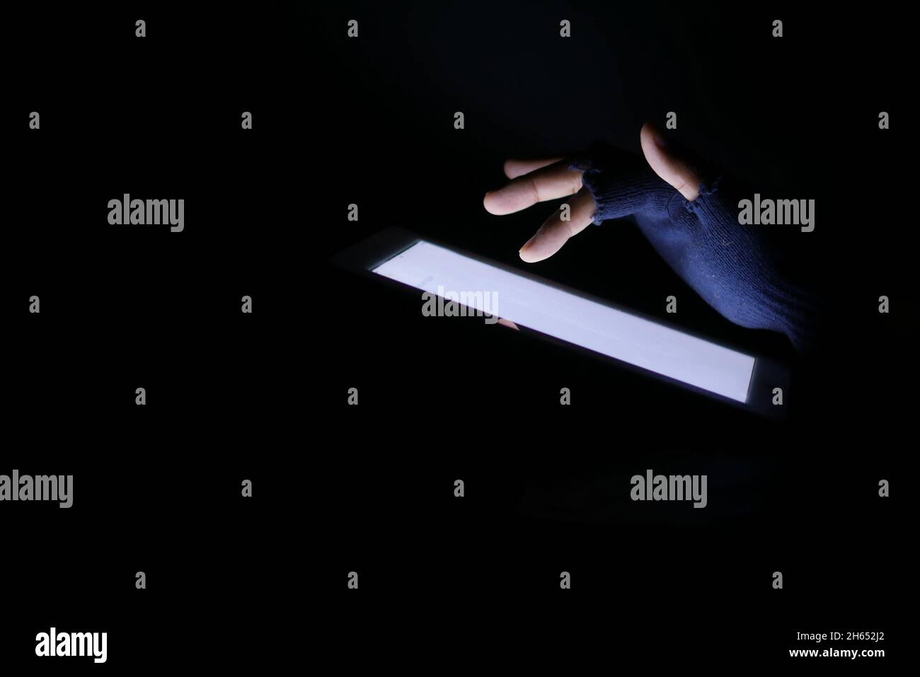 Close up of hacker hand stealing data from digital tablet  Stock Photo