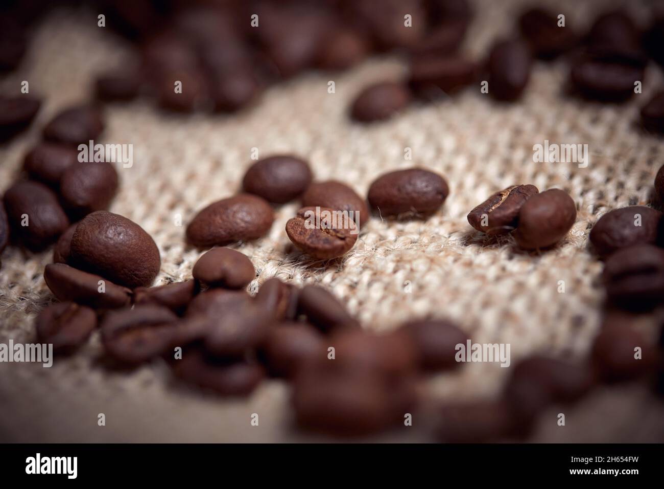 Close-up of aromatic and fragrant roasted coffee beans spread over the bag. Coffee, beans Stock Photo
